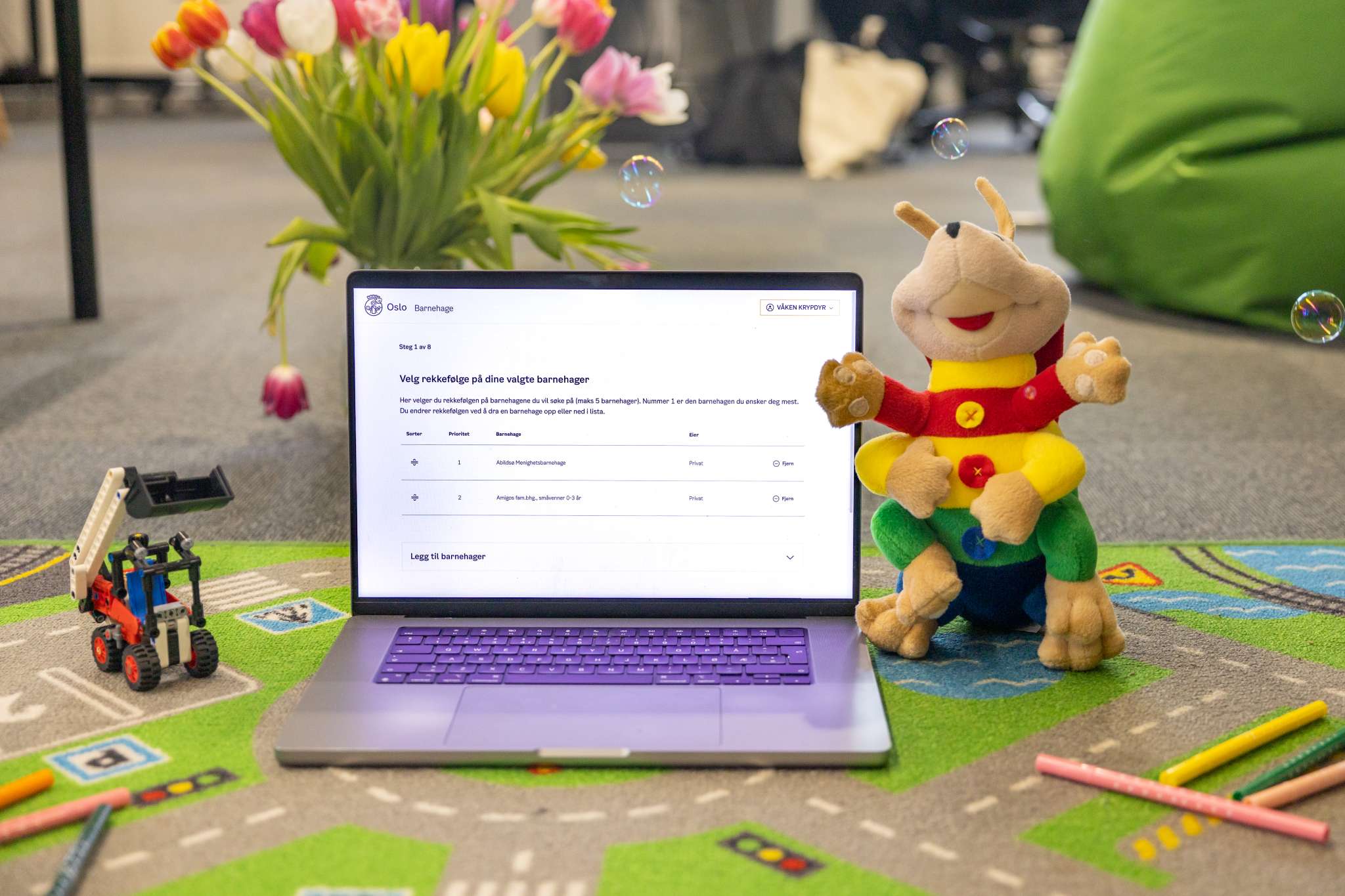 Mac omringet av leker og kosedyr