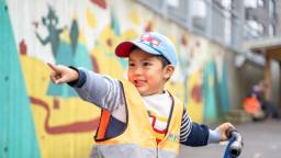 Barnehagegutt med caps og gul vest peker, foto Barnehagegutt med caps og gul vest peker, foto