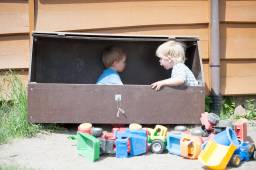 To barn leker sammen inne i en utekasse utenfor en barnehage, foto To barn leker sammen inne i en utekasse utenfor en barnehage, foto