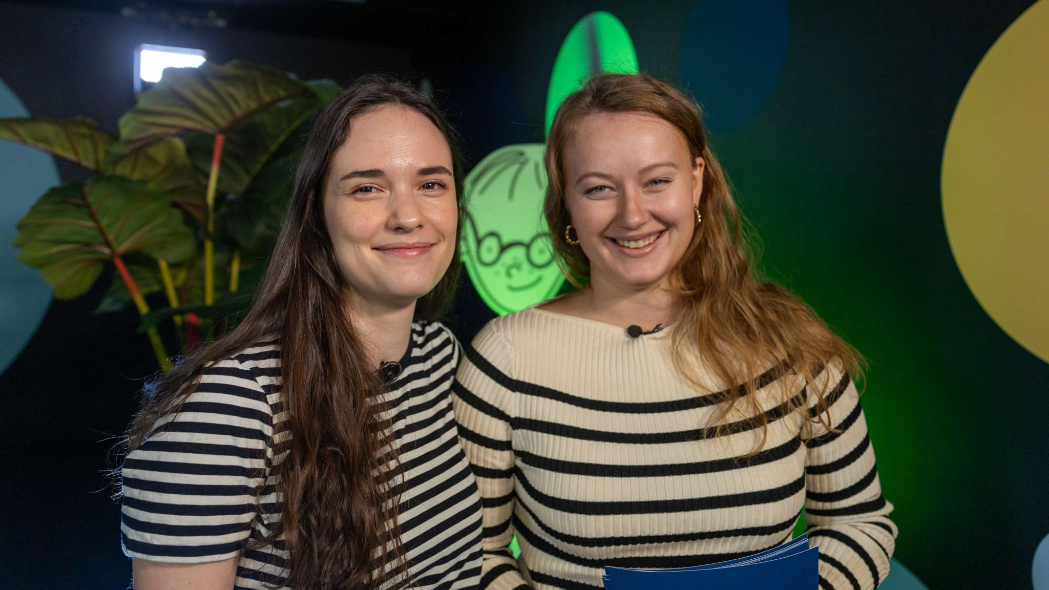 To glade kvinner står i studio til Origo. Foto.