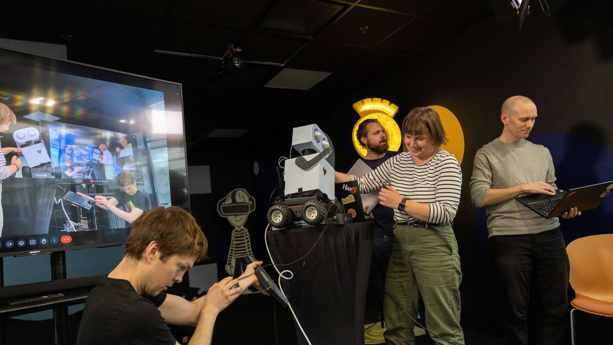 Utviklerteam som forsøker å få en robot til å oppføre seg som den skal, foto