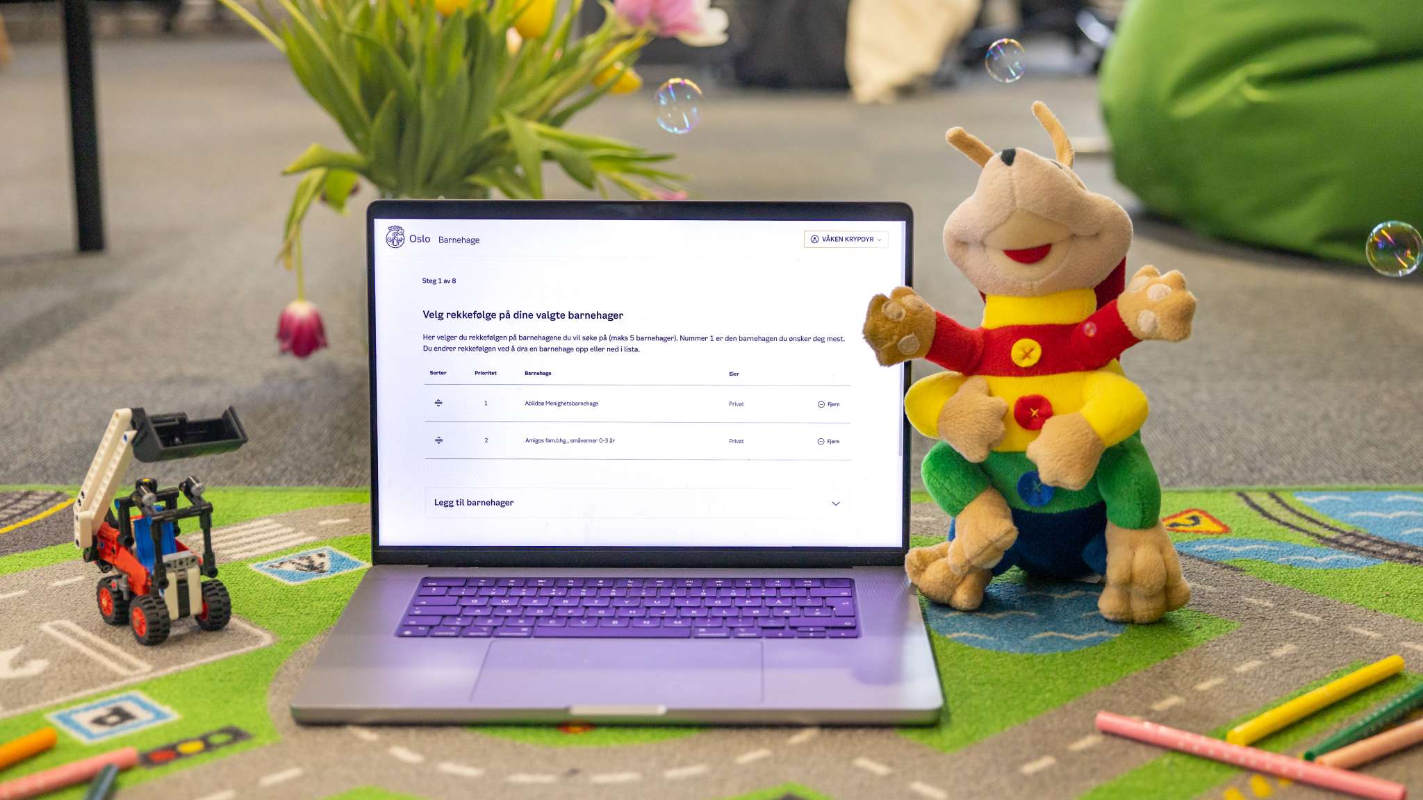 Mac omringet av leker og kosedyr