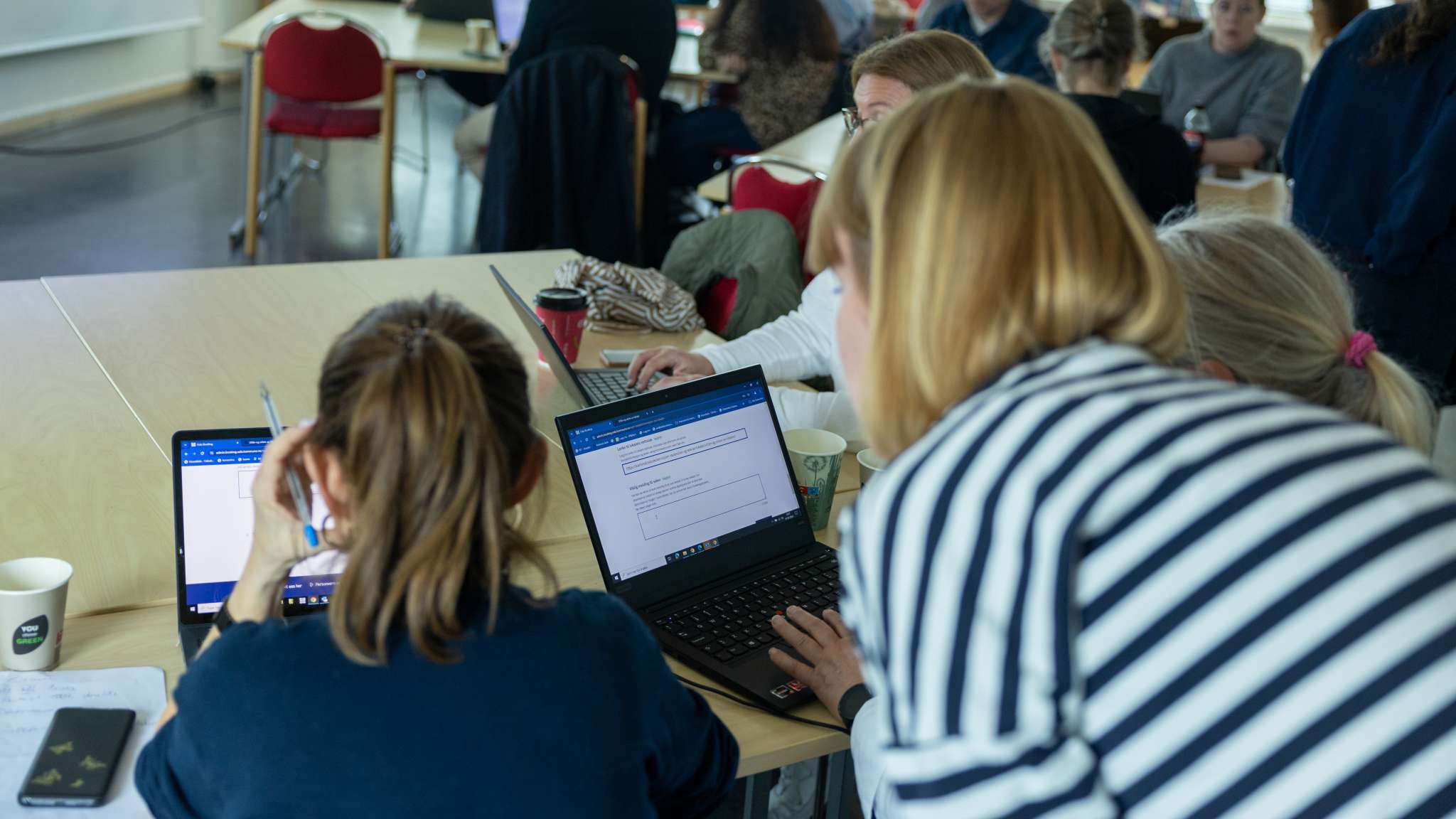 Ansatte fra ulike skoler i Oslo sitter foran hver sin PC og blir vist hvordan de bruker bookingløsningen.