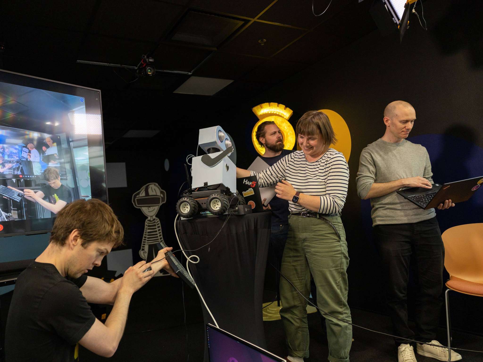 Utviklerteam som forsøker å få en robot til å oppføre seg som den skal, foto