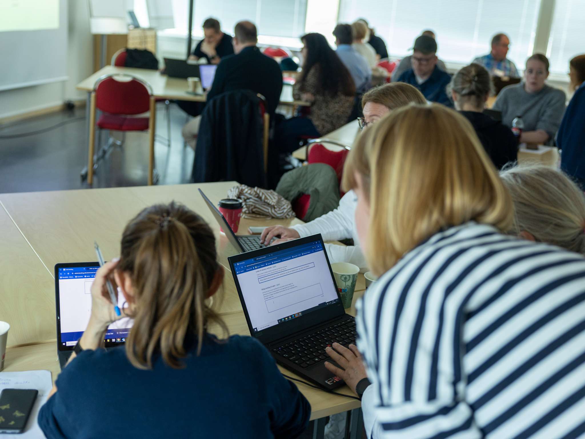 Ansatte fra ulike skoler i Oslo sitter foran hver sin PC og blir vist hvordan de bruker bookingløsningen.