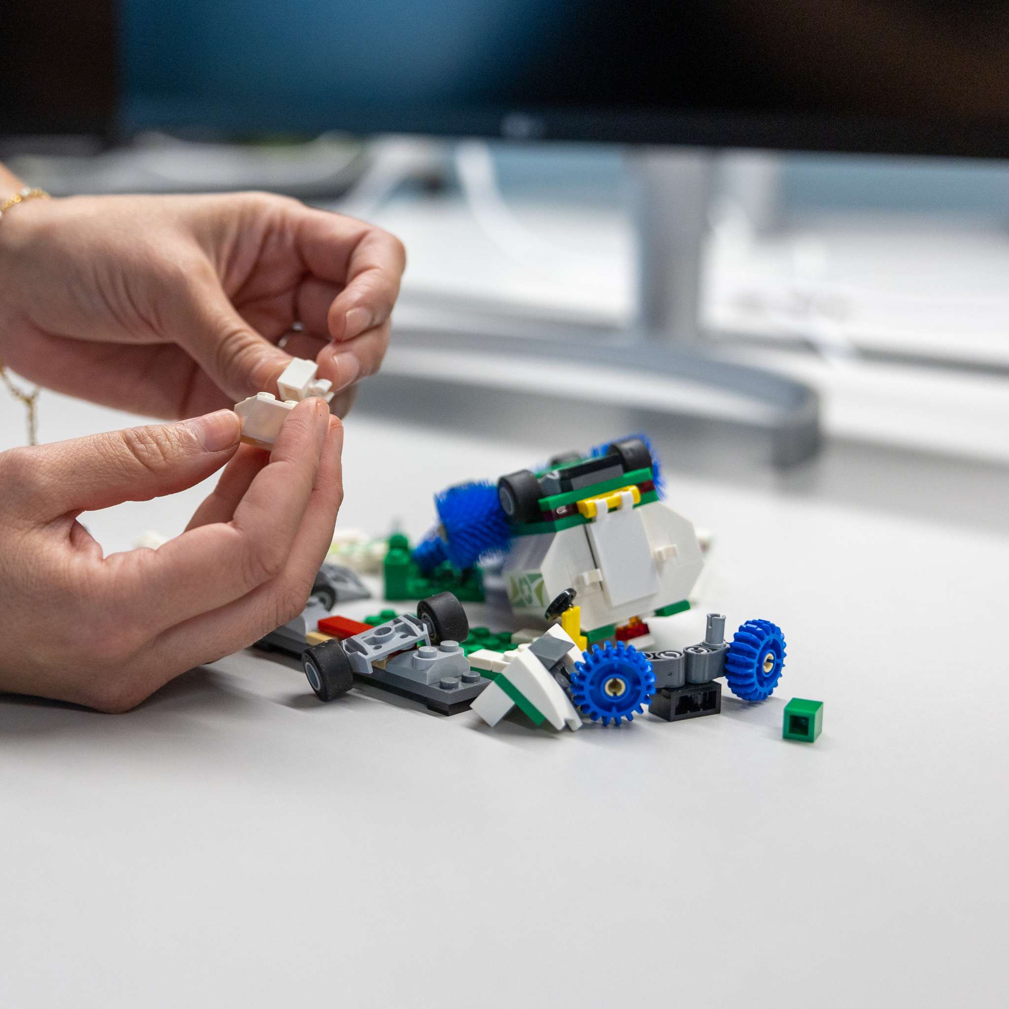 Bilde av hender som bygger lego. Foto.