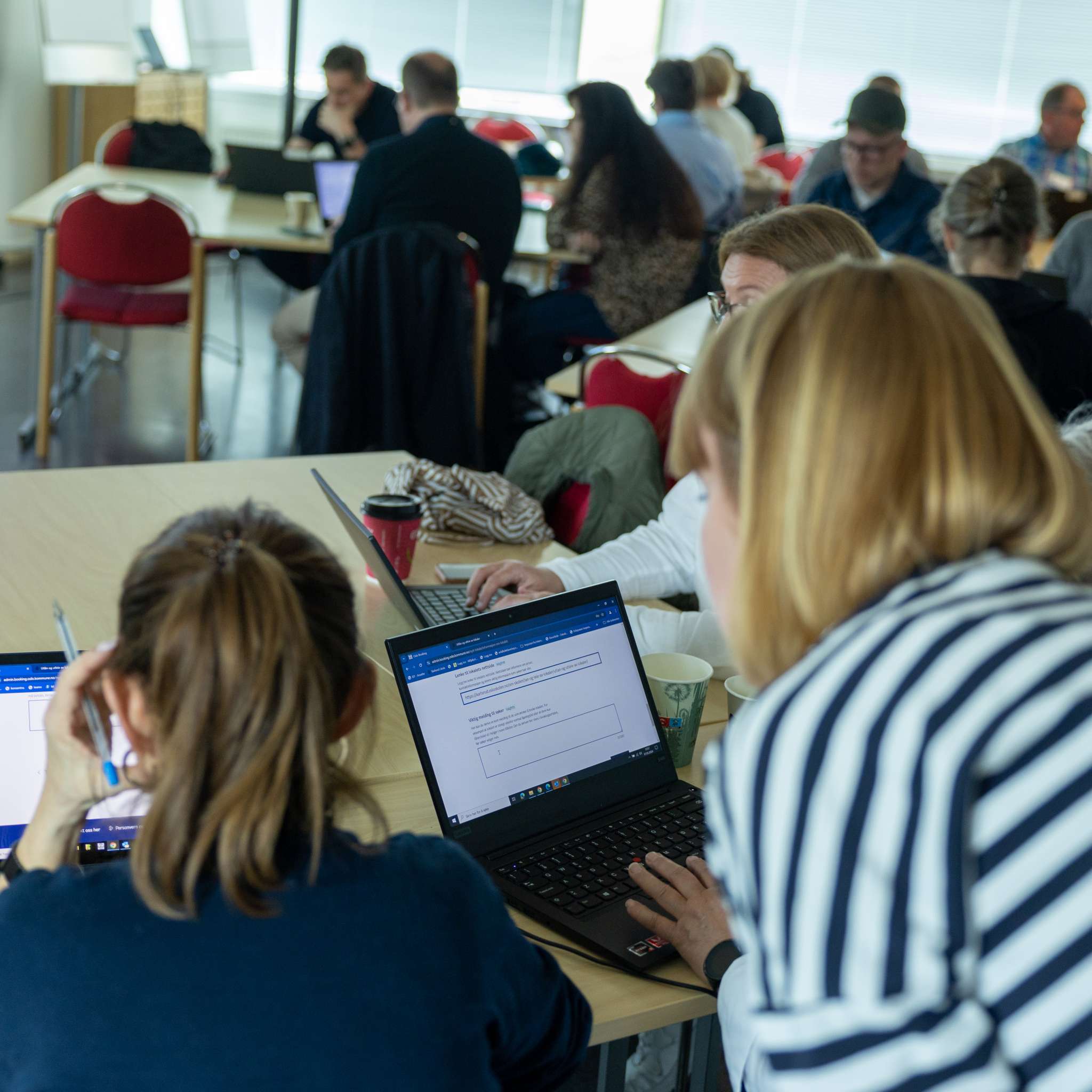 Ansatte fra ulike skoler i Oslo sitter foran hver sin PC og blir vist hvordan de bruker bookingløsningen.
